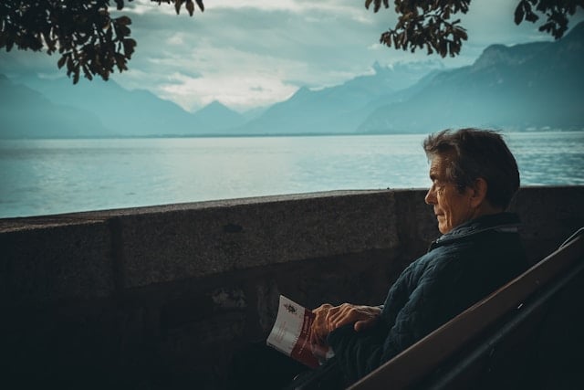 Reviewing Andrew Huberman's Supplement Routine in 2025 9 Older man looks out onto the water holding a book