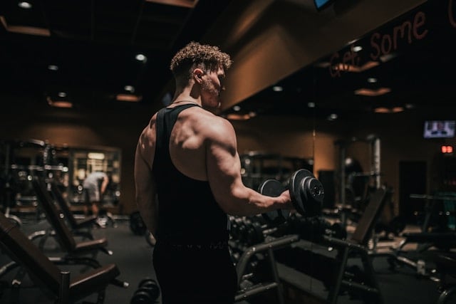 Reviewing Andrew Huberman's Supplement Routine in 2025 6 Bodybuilder lifting dumbbells in a dimly lit gym