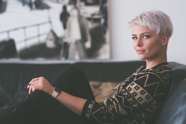 Should Women Take NAD+ Supplements? 8 An accomplished woman holds her glasses on a modern sofa