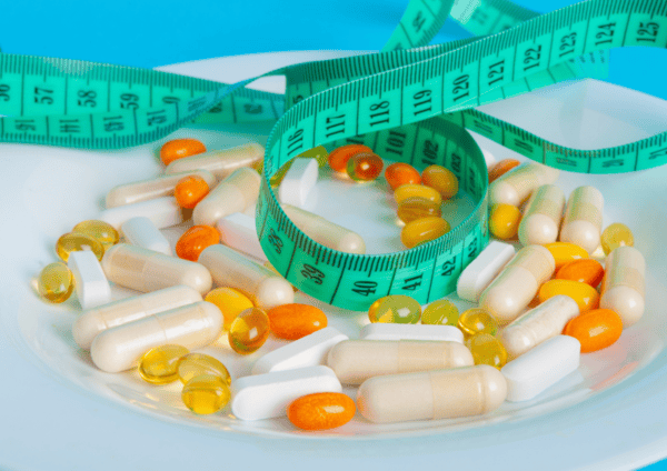 Can NAD Supplements Help You Lose Weight? 6 a plate of pills and a measuring tape