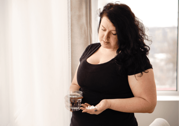 Can NAD Supplements Help You Lose Weight? 11 a woman holding a glass of water and a glass of water