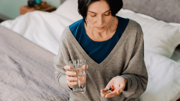 What's the Difference Between NMN vs NAD? 7 Middle aged woman taking a supplement