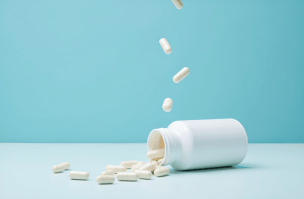 11 Promising Benefits of NMN Supplements 5 NMN supplement capsules falling out of bottle