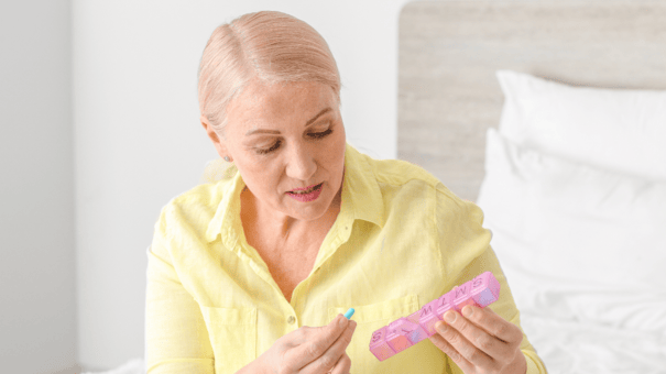 NMN vs. Niacin: Safety and Efficacy for Longevity 7 An image of a matured woman deciding which pills to take.