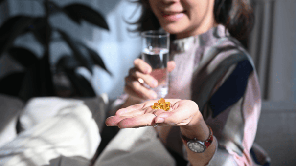 NMN with TMG: Benefits, Dosage and Risks 9 An image of a middle-aged woman taking supplement