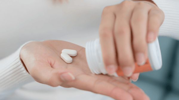 NMN Dosage Guide: How to Safely Take NMN 5 An image of a woman hand getting supplements