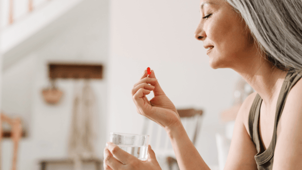 NMN Dosage Guide: How to Safely Take NMN 6 An image of a matured woman taking supplements
