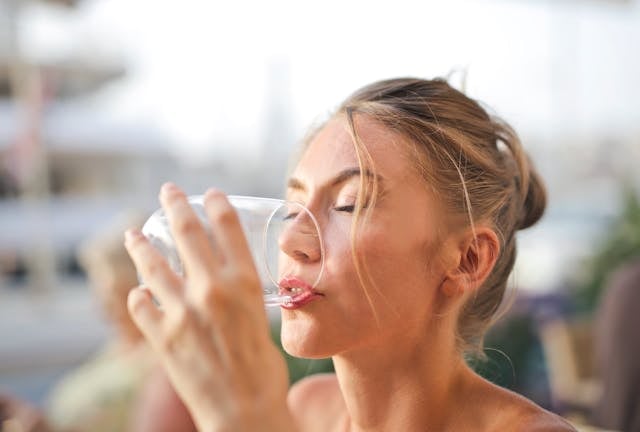Quercetin vs. Fisetin: Differences and Combined Benefits 9 Woman taking quercetin supplements with a glass of water