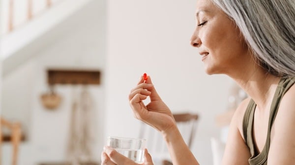 5 Surprising Health Benefits of Quercetin You Need to Know 8 Middle-aged woman taking a supplement