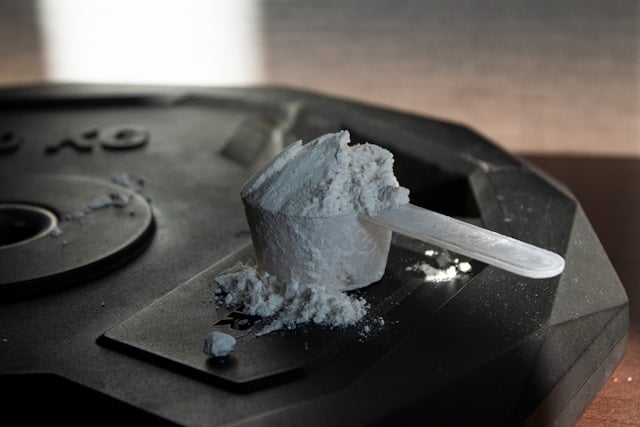 Does Creatine Help Reduce Sleep Deprivation? 6 A scoop of creatine powder on a weight plate