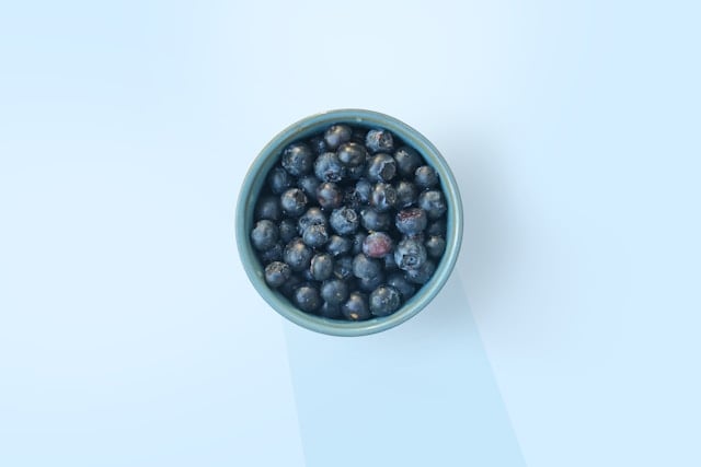 5 Surprising Health Benefits of Quercetin You Need to Know 4 A bowl of blueberries on a plain background