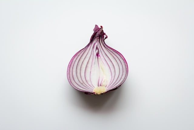 5 Surprising Health Benefits of Quercetin You Need to Know 7 A red onion cut in half on a white background