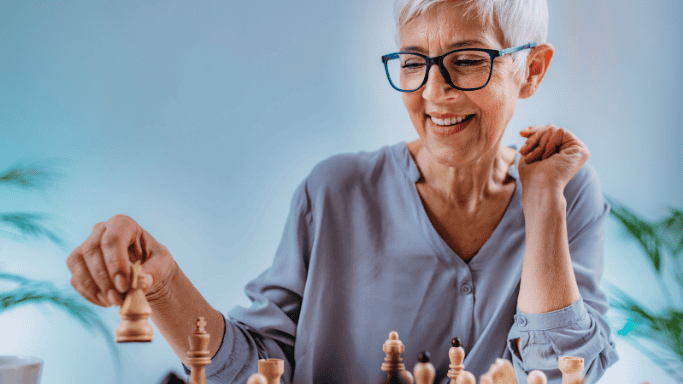 An image of a matured woman playing chess
