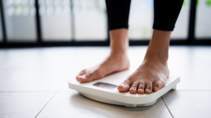 Closeup of woman's feet weighing herself on a scale
