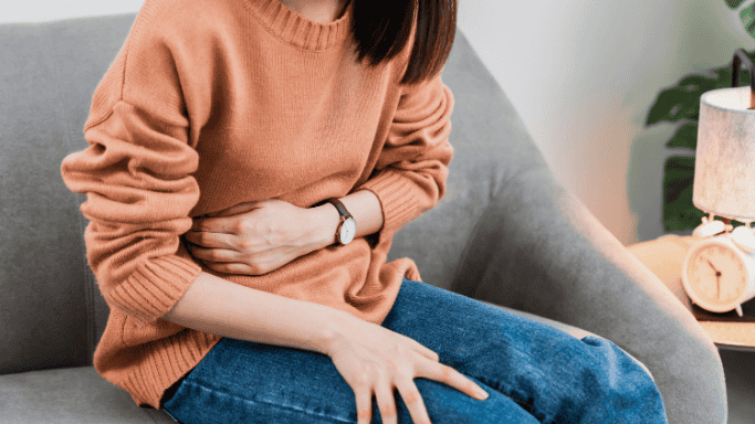 What to Know About Creatine and Sexual Health 9 An image of a woman with an upset stomach