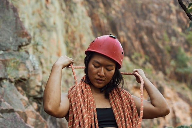 Is Creatine Worth It for Climbing Performance? 11 Woman climber with bungee ropes around her and a red helmet