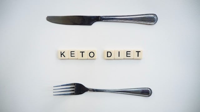 Should You Take Creatine on a Keto Diet? 4 A fork and knife arrange near scrabble pieces that read Keto Diet
