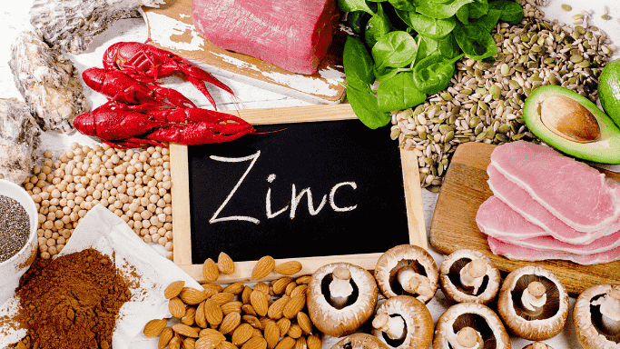 Can Vitamin C and Zinc Prevent or Shorten Your Cold? 5 An image showing a variety of zinc-rich foods arranged on a table, including avocado, lobster, meet, pumpkin seeds, chickpeas, mushroom, and almonds.