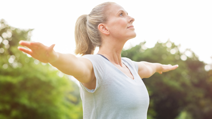 8 Ways to Boost Your Glutathione Levels Naturally 9 An image showing a woman standing outdoors with arms outstretched, symbolizing taking proactive steps toward better health and well-being.