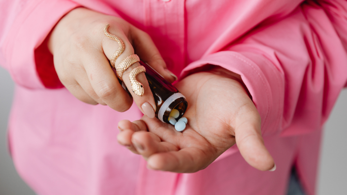 NSAID Alternatives: 11 Non-NSAID Pain Relievers to Consider 4 An image of a woman holding a medicine bottle, pouring pills into her hand.