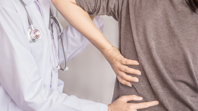 NSAID Alternatives: 11 Non-NSAID Pain Relievers to Consider 7 An image showing a healthcare professional examining a patient's back and shoulder, assessing musculoskeletal pain during a physical evaluation.