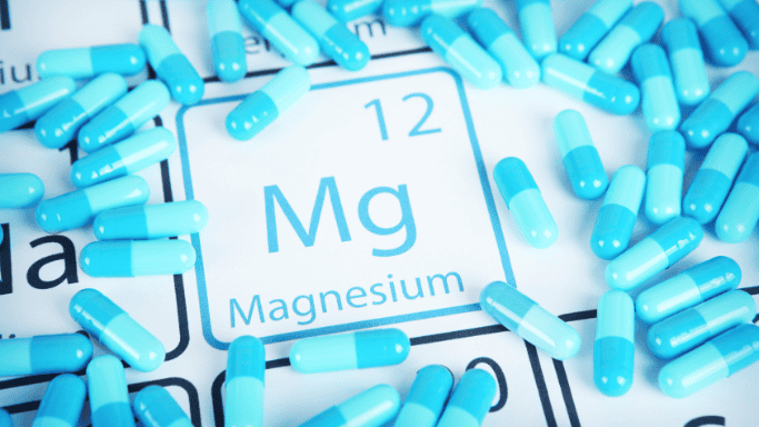 An image showing multiple magnesium supplement pills scattered on a surface.