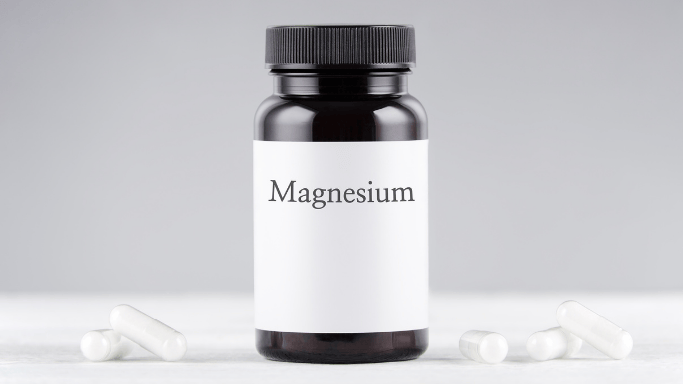 10 Vitamins and Minerals with Anti-Aging Benefits 7 An image showing a bottle of magnesium with several tablets placed beside it on a surface.