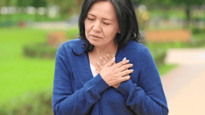 Is Niacin Good for Your Heart? New Studies Show Hidden Risks 4 A woman holding her chest with pale lips, appearing to be in discomfort, possibly indicating symptoms of heart disease.