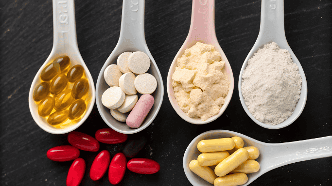 11 Supplements to Support Lungs and Respiratory Health 4 Assorted supplements in different forms—capsules, tablets, powders—arranged in ceramic spoons on a dark surface.