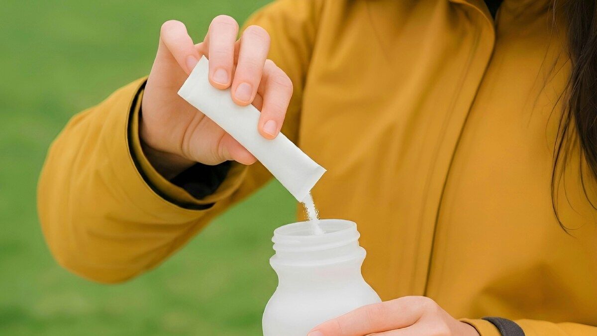 A woman pours magnesium powder into her water bottle