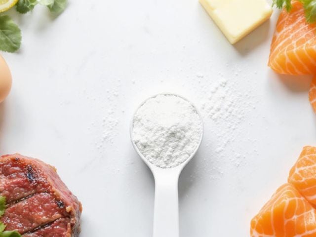 A scoop of creatine powder surrounded by keto-friendly foods