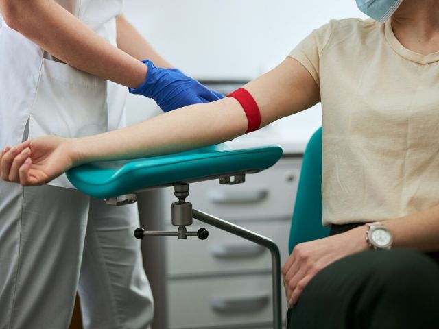 A nurse preparing a woman for an ApoB blood test.