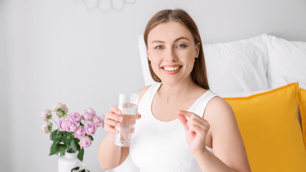 An image of a healthy woman taking supplement