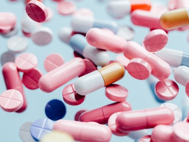 NAD dosage featured image - NAD supplements falling against blue background