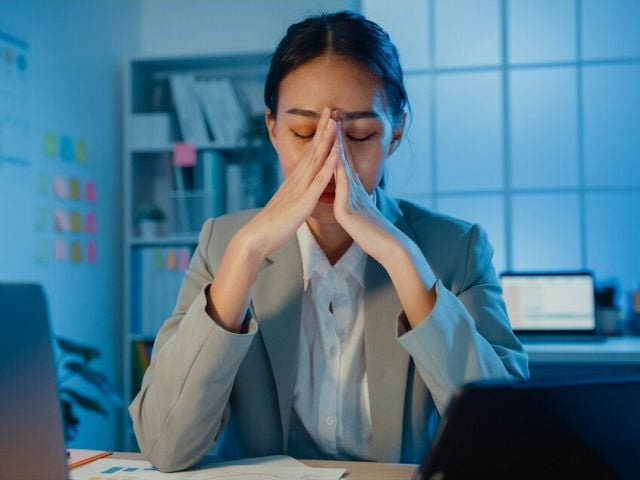 How to test cortisol levels - featured image with an overworked and stressed woman