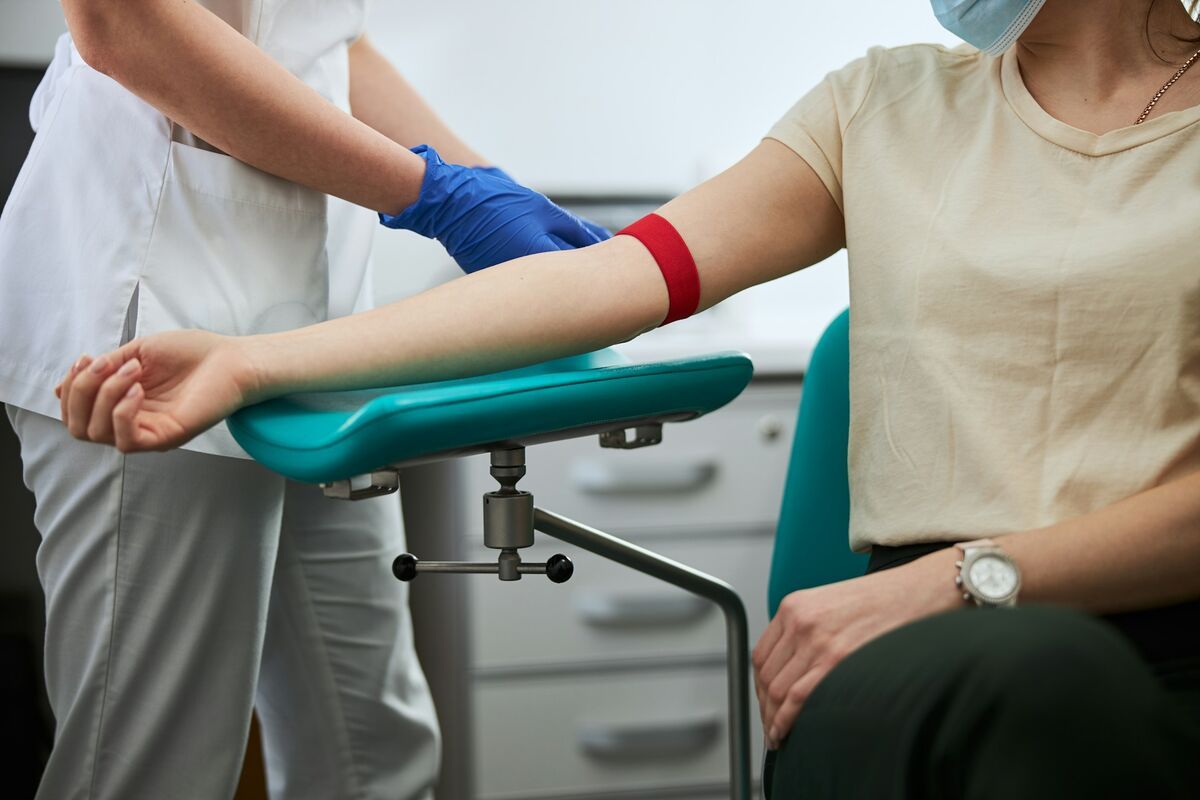 A nurse preparing a woman for an ApoB blood test.
