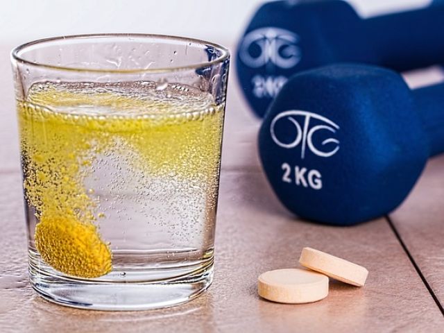 Biohacking supplements in a glass of water by dumbbells