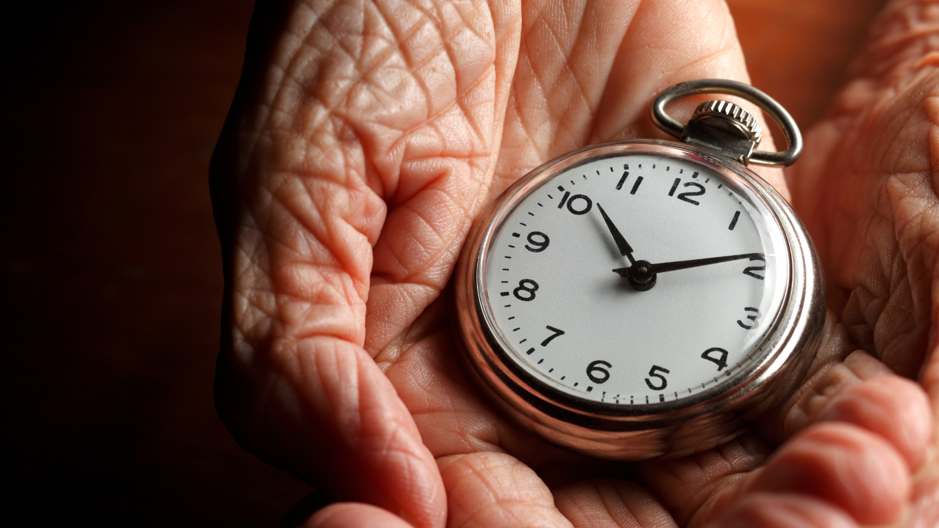 An image of an old woman holding a clock to depict epigenetic aging