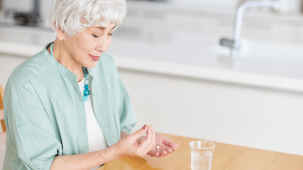 An image of an old woman taking supplement