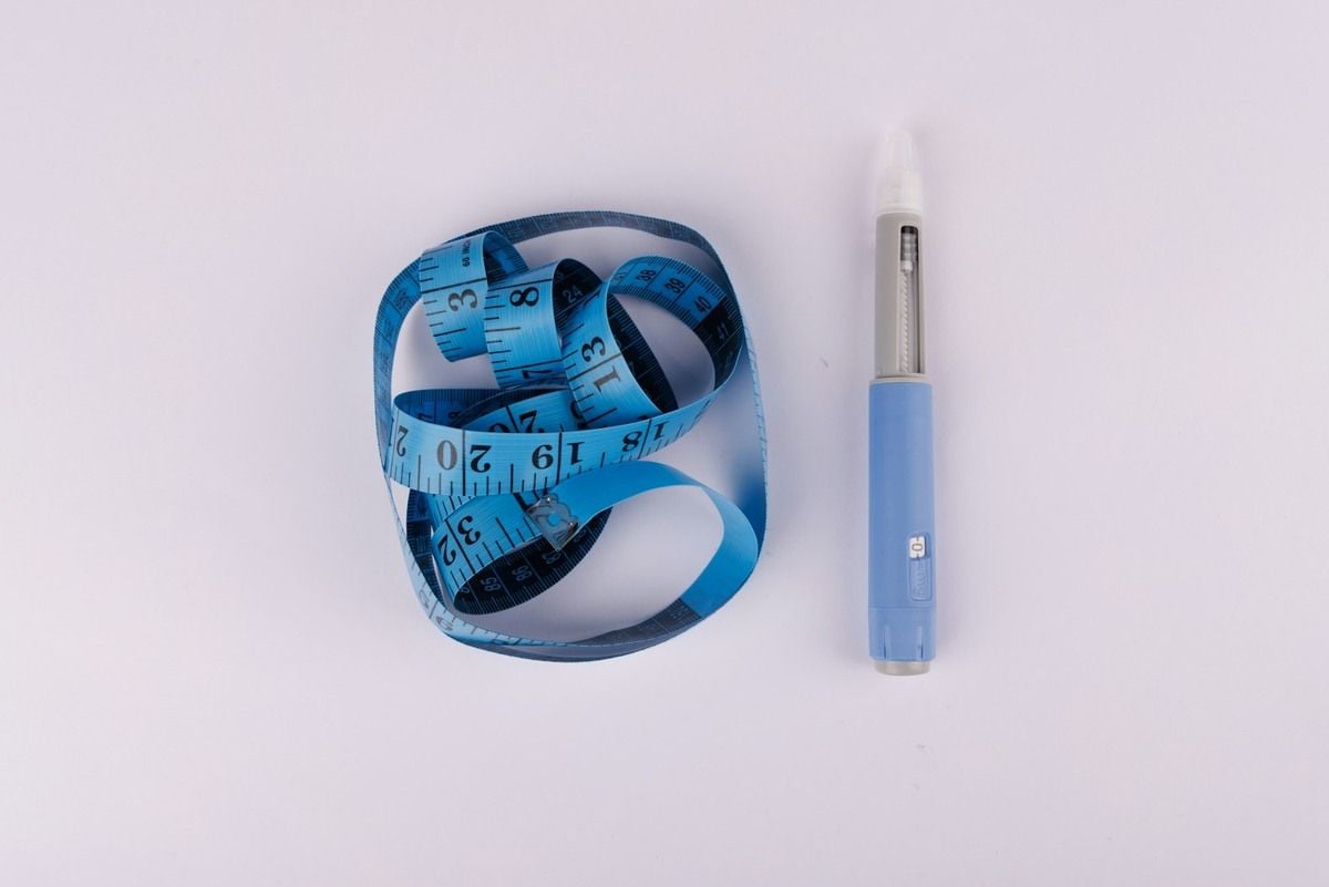 Image of GLP-1 medication next to body tape measure