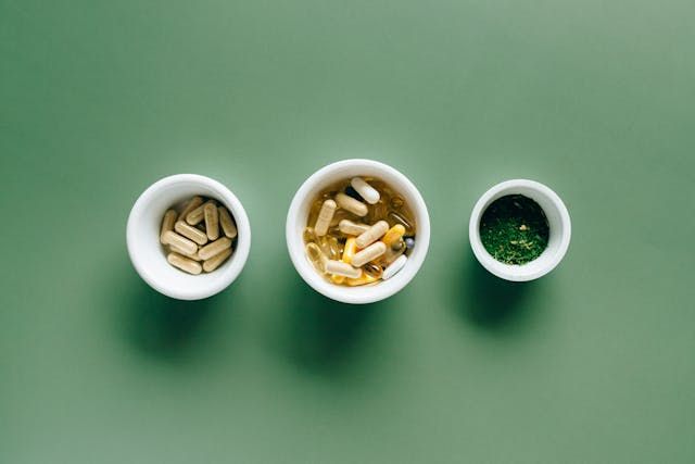 Supplements in small bowls on a green background