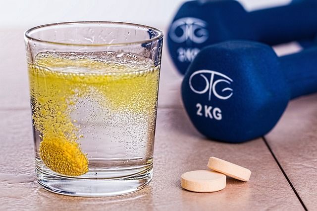 Biohacking supplements in a glass of water by dumbbells