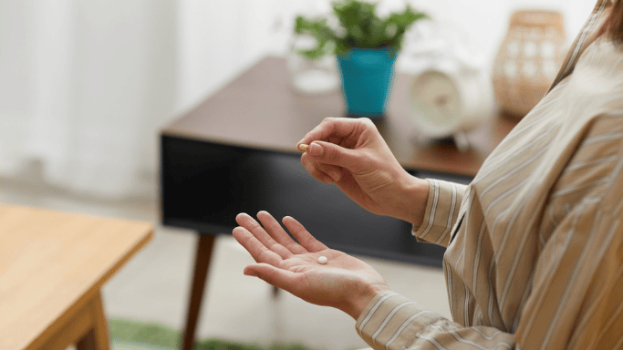 A close up image of a woman taking supplement
