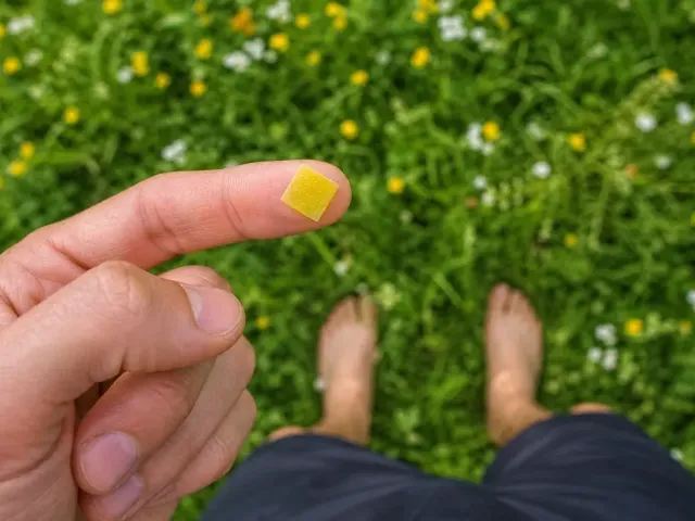 A man standing outside with a NAD+ patch on his finger, first-person view.