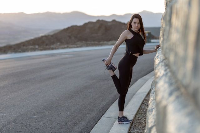 Athletic woman doing knee stretches on her run