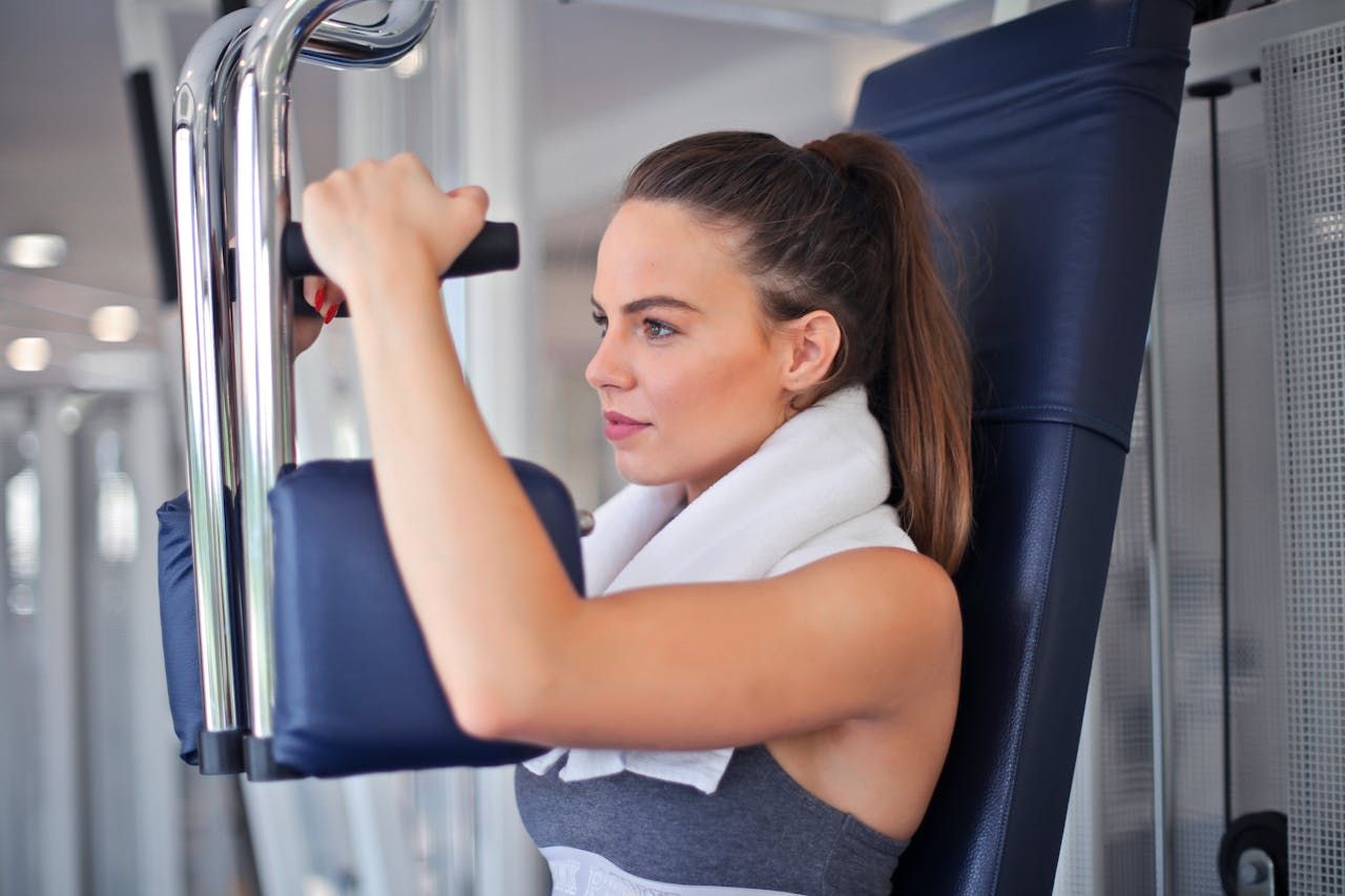 A fit woman doing machine flys in the gym