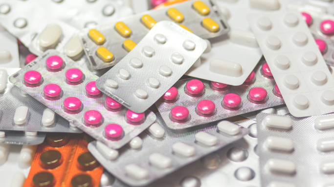 Assorted blister packs of various pills in different colors and shapes, representing a variety of non-NSAID pain relief medications.