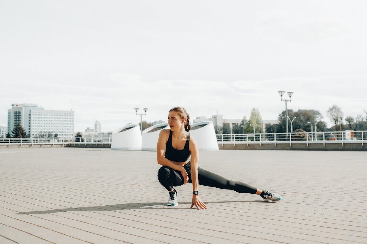 A woman athlete doing stretches on a boardwalk