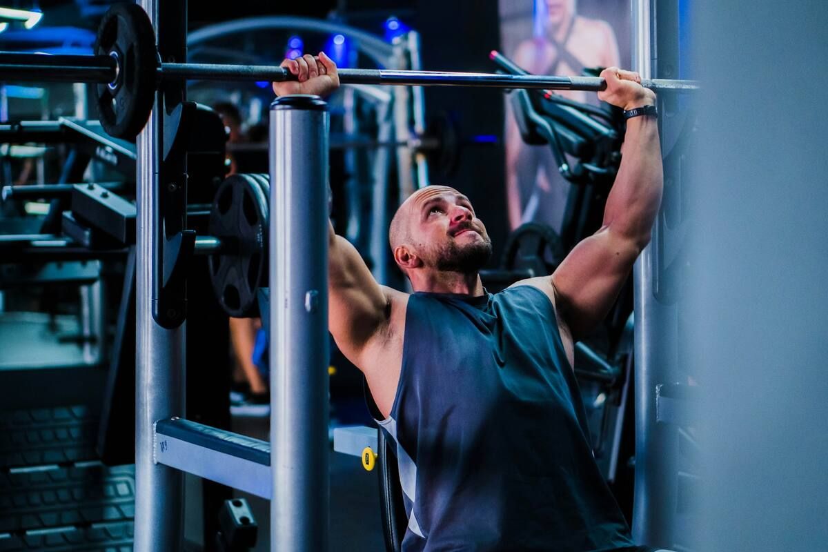 A man doing shoulder presses in the gym.