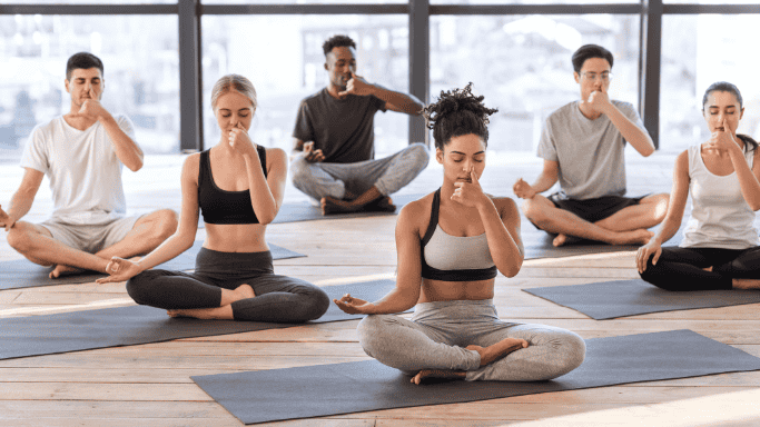 Adult men and women doing breathing exercise.